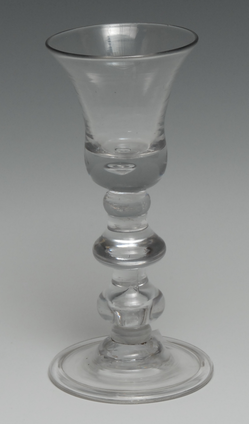 An 18th century double-baluster wine glass, bell-shaped bowl, spreading circular foot, 15.5cm high, c. 1740
