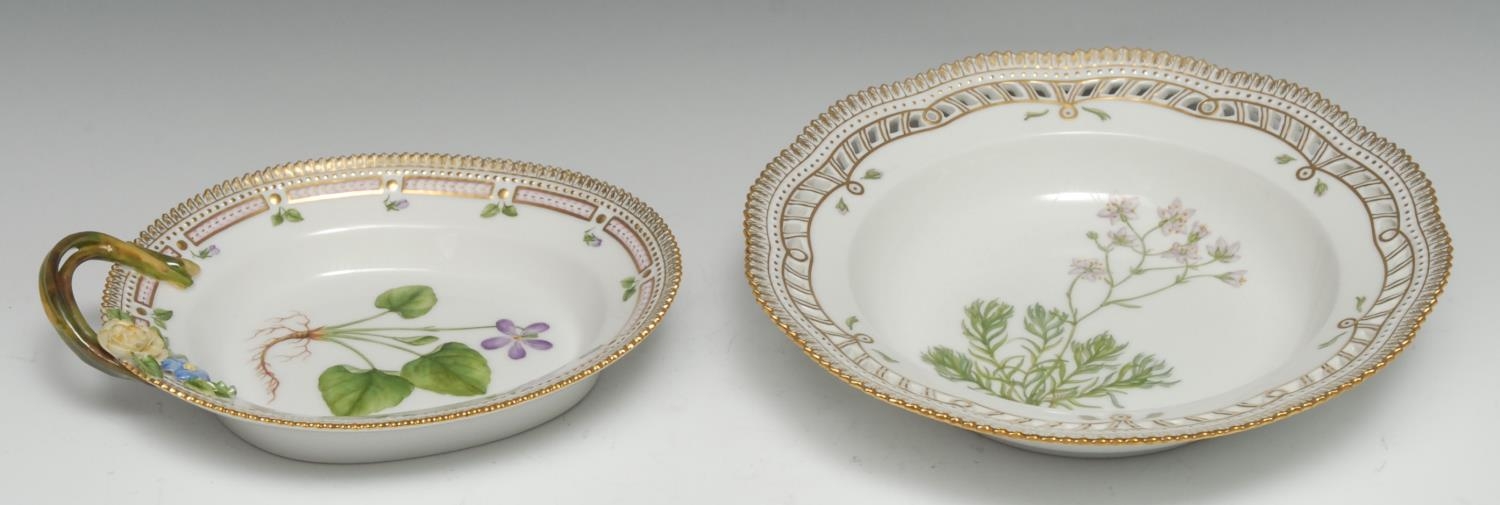 A Royal Copenhagen Flora Danica shaped circular dish, painted with Saxifraga Hypnoides, titled to verso, pierced border picked out in gilt, 24cm diam, printed mark;  a similar dish, Viola Ulignosa Bess, 22cm wide, printed mark (2)
