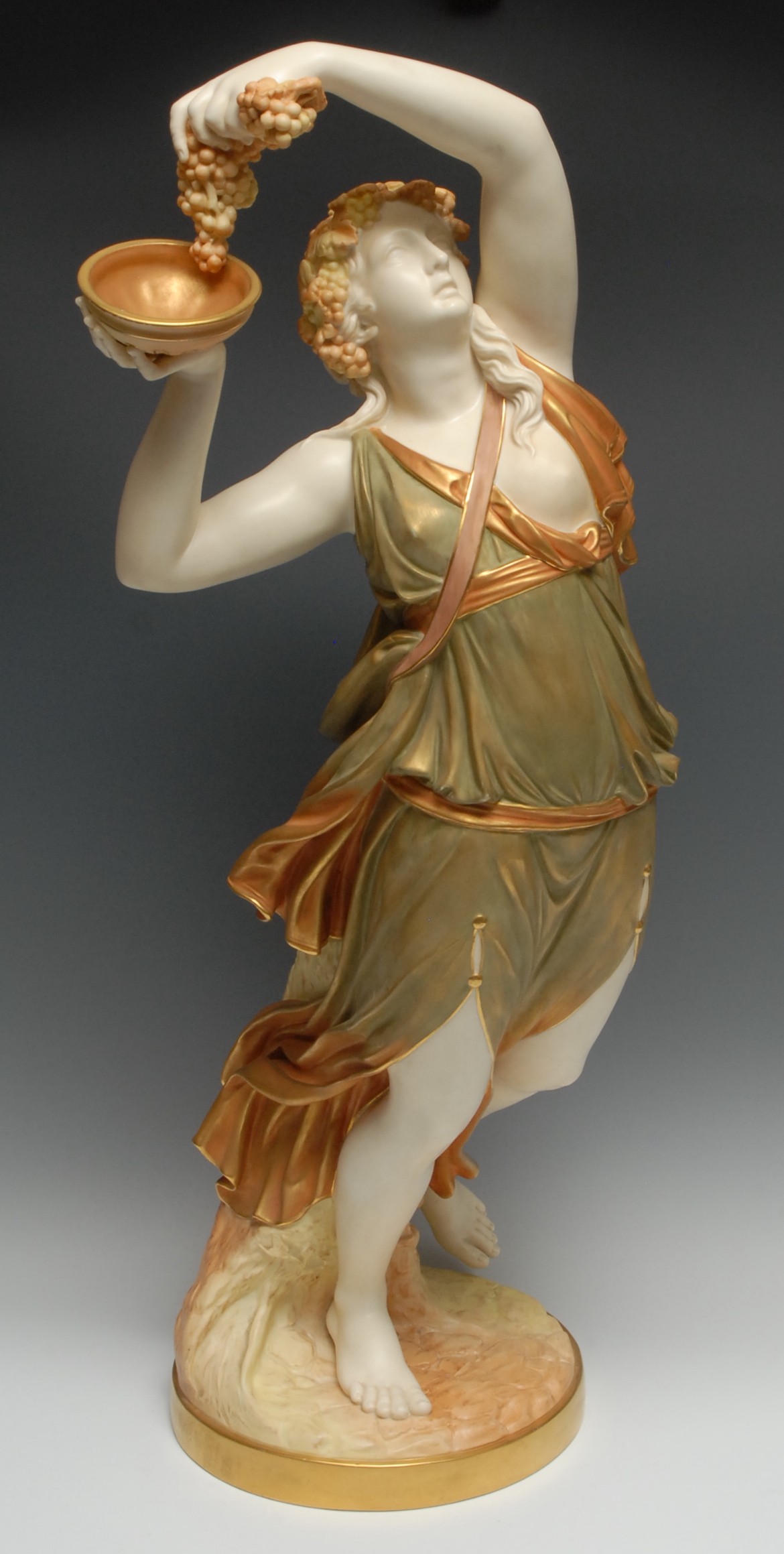 A large Royal Worcester figure, Bacchante Dancing, with grapes, in burnished gilt, green and ivory, 69cm high, printed crown and circle mark in puce, date code for 1896, shape no.534
