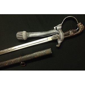 WW2 Third Reich Heer Officers Lion Head Sword with 860mm long fullered single edged blade, maker marked "Alcoso, Solingen". Wire bound black celluloid grip, Lion's eyes set with red glass. Silver finish to guard. Eagle to crossguard. Complete with scabbard wth remains of original black paint. Reproduction sword knot.
