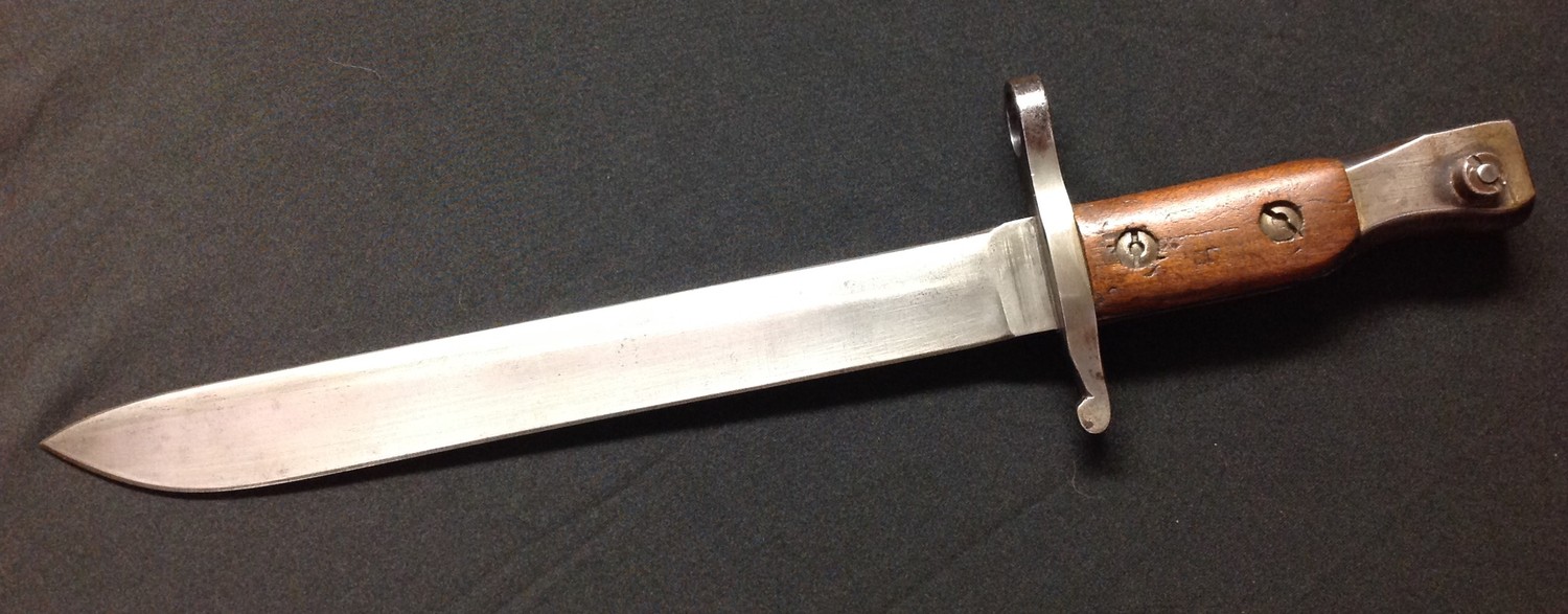 WW1 Canadian Ross Bayonet, first production version with original unmodified blade tip. Single edged blade 255mm in length. Unmarked. Crossguard has inspection marks. Working release catch. Pommel is marked "Ross Rifle Co. Quebec. Patented 1907." Overall length 373mm. No scabbard.