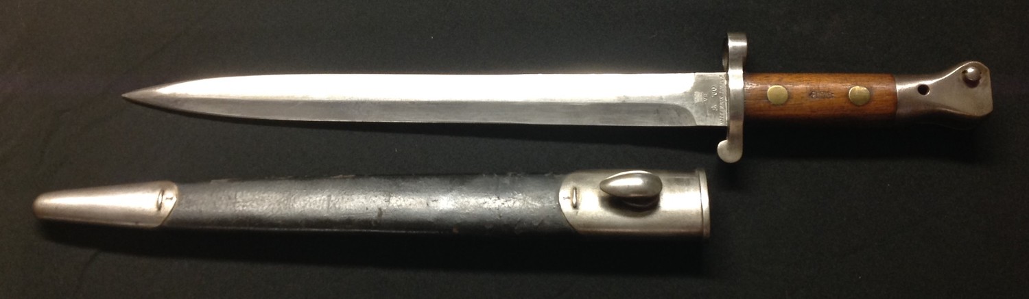British 1888 pattern Lee Metford bayonet. Double edged blade 302mm in length, maker marked "Wilkinson, London" and dated 5 / 00 along with Crown and VR and inspection stamps. Overall length 425mm. Working release catch. Complete with scabbard which is well marked with inspection stamps.