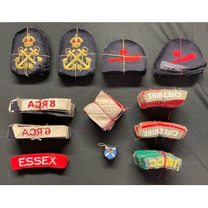 WW2 British and Canadian Army and Navy insignia, unissued still tied together with cotton. Essex Regt x 12, Cheshire Regt x 48, IWGC pre 1960 shoulder titles x 24, RN Petty Officers badges x 24, RN Trade badges x 24, 6 RCA, 8 RCA, etc.
