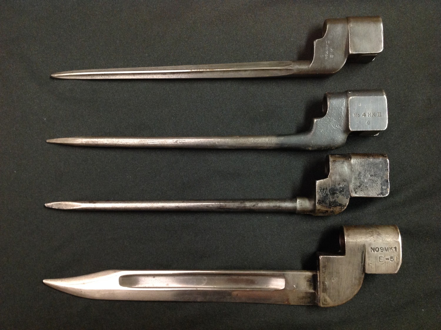 WW2 British No 4 MkI Cruciform Bayonet, rare early production model by the Singer Sewing Machine Company. Correctly marked GR Crown, No 4 MKI SM, opposite side numbered 577, along with SM41 to release catch. Blade length 190mm, overall length 250mm. No scabbard. Plus two No 4 MKII Bayonets, both without scabbards and a No9 Mk1 bayonet without scabbard. (4)
