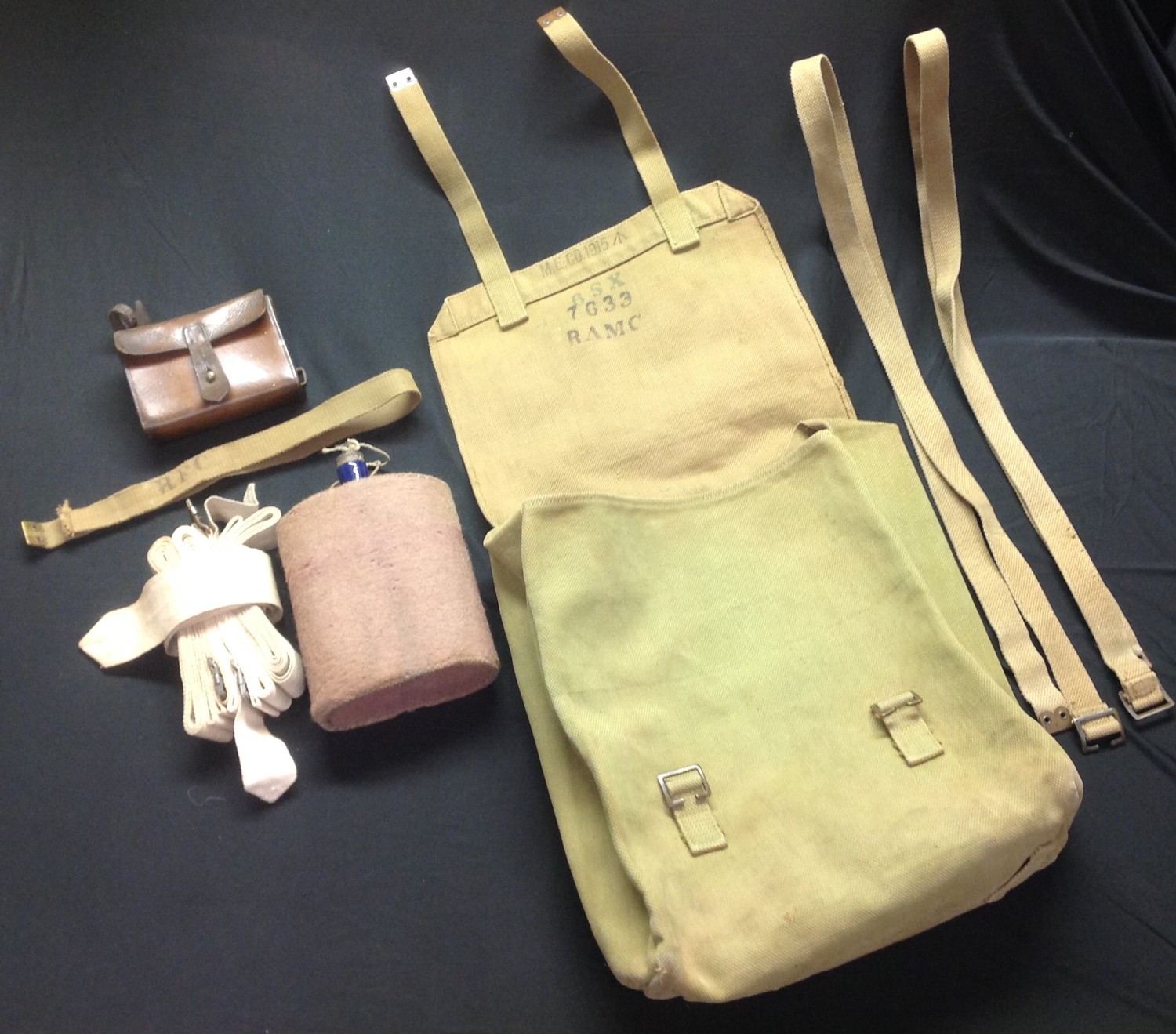 WW1 British 1908 Pattern Webbing Large Pack, maker marked and dated "MECO 1915" along with unit markings "6SX" "7633 RAMC": two web straps: water bottle with cover: RFC marked web strap (cut down) small leather pouch with alloy container with: four unmarked white canvas straps, possibly medical. (Q)