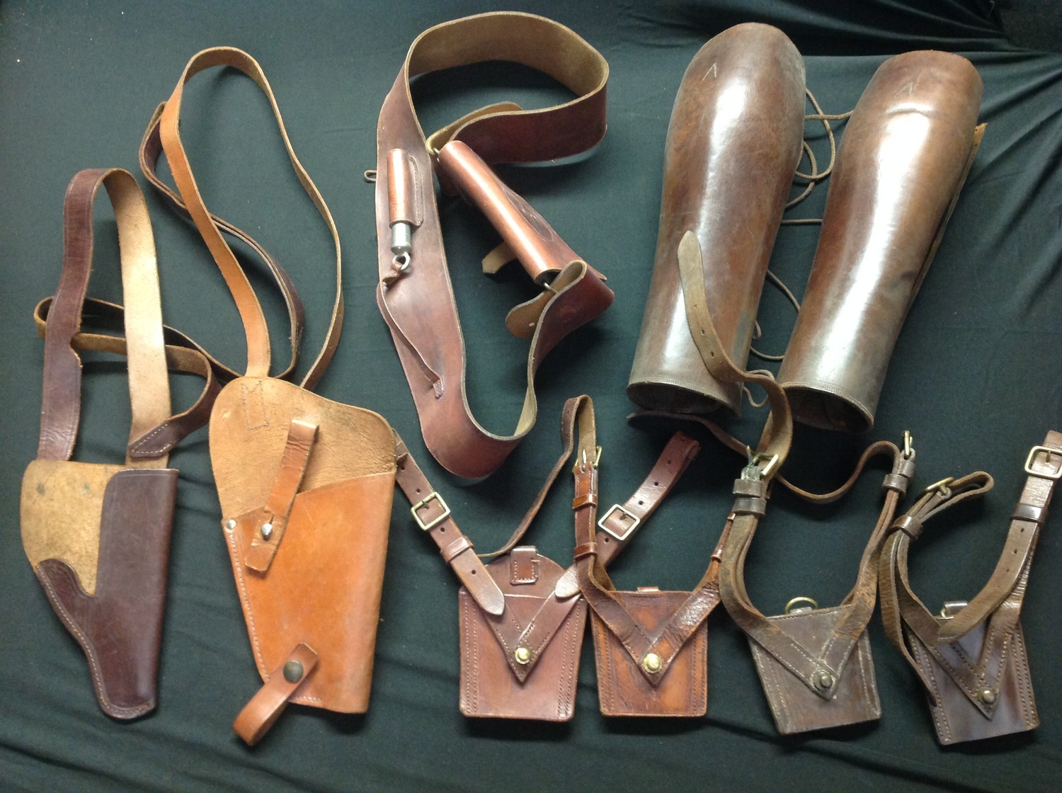 WW2 British / US / German leatherwork collection to comprise of: two leather shoulder holsters, both unmarked: four Sam Brown leather Sword frogs: various leather straps and cross straps: pair of high leg leather gaiters: Cross strap with pouch and Whistle: US holster adapter dated 1946: single German Luftwaffe issue brown leather K98 ammo pouch a/f. (Q)
