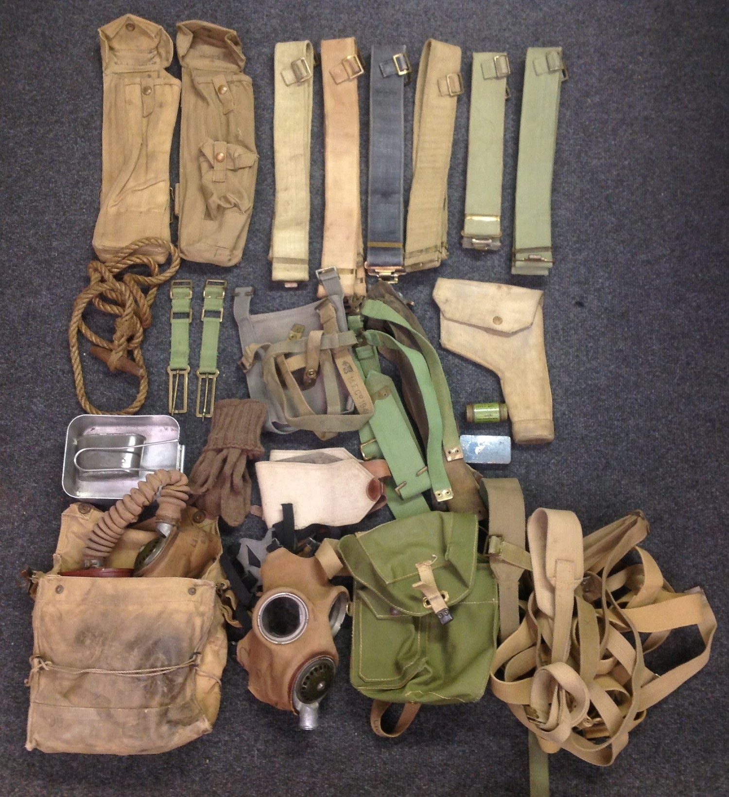 WW2 British 1937 Pattern Webbing collection comprising of: a pair of Lanchester SMG Pouches, both dated 1943 by different makers: Pistol holster dated 1942: Six 37 pattern belts (One Indian made) : two water bottle carriers, one of each pattern: two pairs of L straps: various web straps: pair of brace adapters: Toggle rope (thin rope type): Lightweight respirator bag 1944 dated: half a mess tin dated 1945: pair of woolen gloves: facepeice from a respirator: Respirator and 1938 dated bag: tin of anti dim: tin of anti - gas ointment No5. (Q)