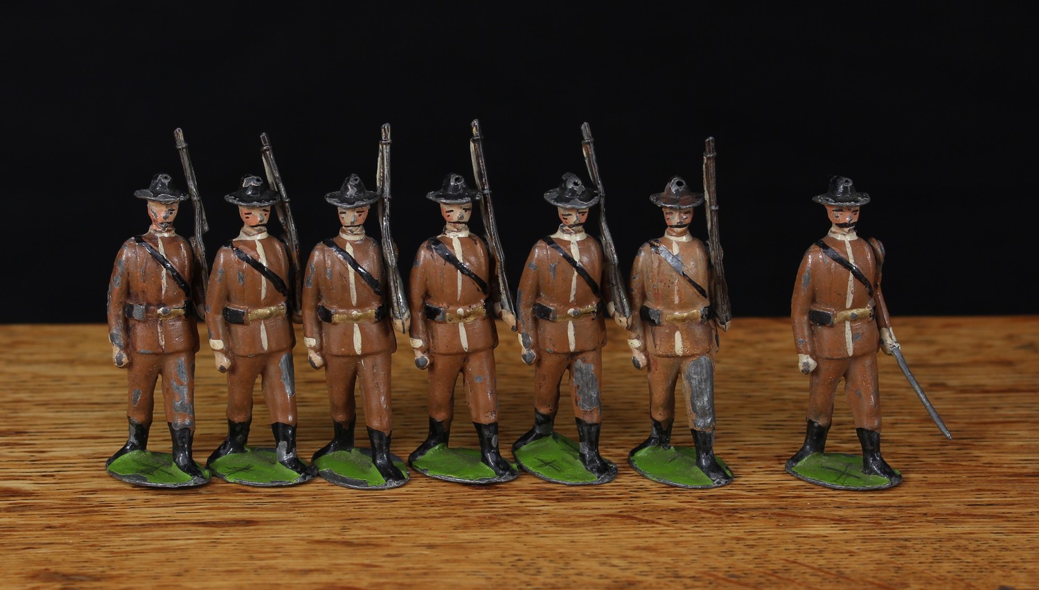 W Britain (Britains) No.26 Boer Infantry, comprising six infantrymen figures, each marching at the slope and a marching officer, each with movable arms and unmarked oval bases, unboxed (7)