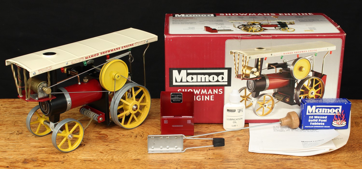 A Mamod live steam Showmans engine, maroon body with cream canopy, yellow spoked wheels and yellow flywheel, boxed with steering rod, scuttle piece, burner tray, a Mamod bottle of lubrication oil, literature and an unused box of Mamod twenty waxed solid fuel tablets