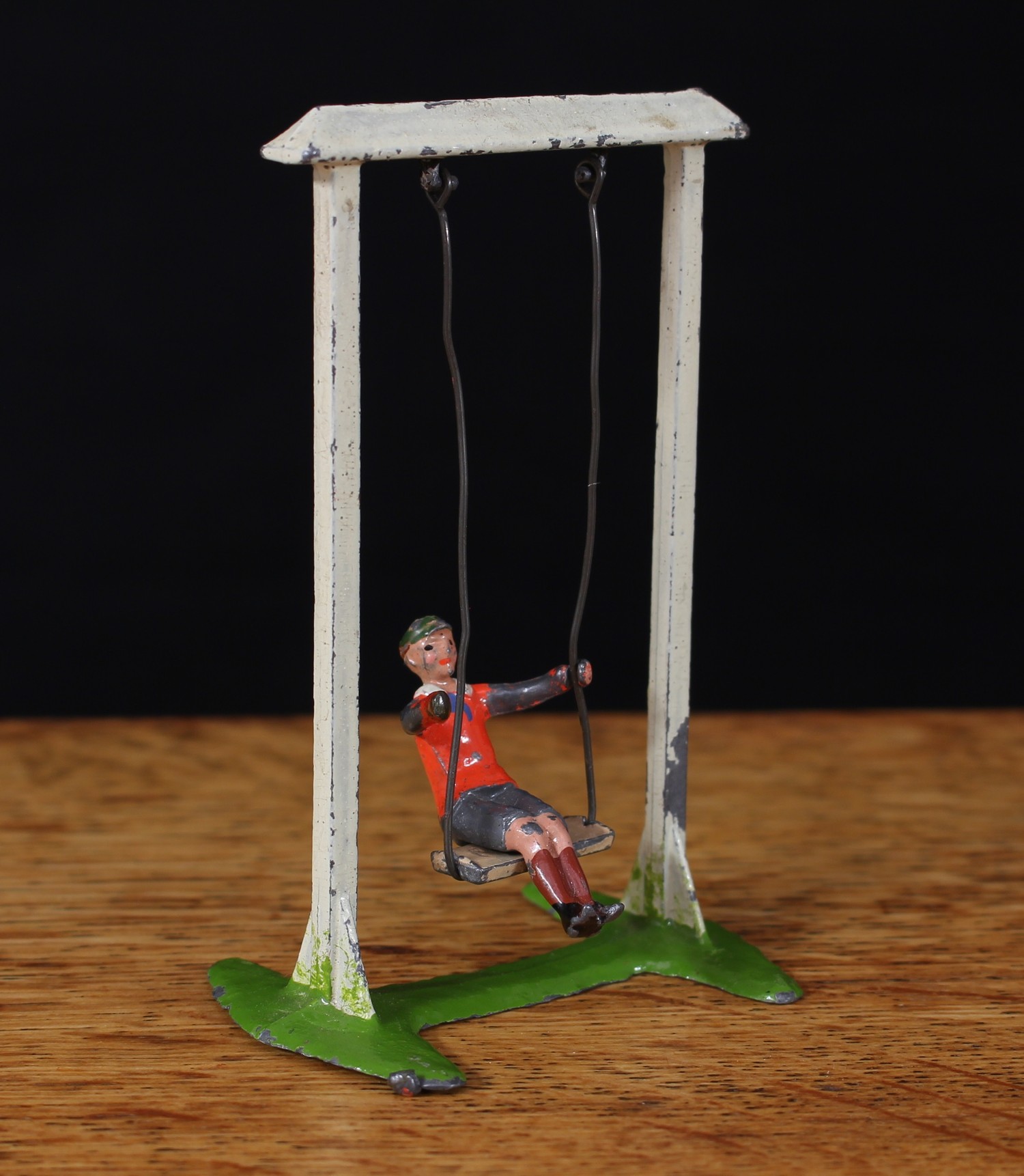 W Britain (Britains) No.619 boy on a swing, comprising of painted lead seated figure of a boy in a red jumper with grey shorts on a white framed swing with single seat, unboxed