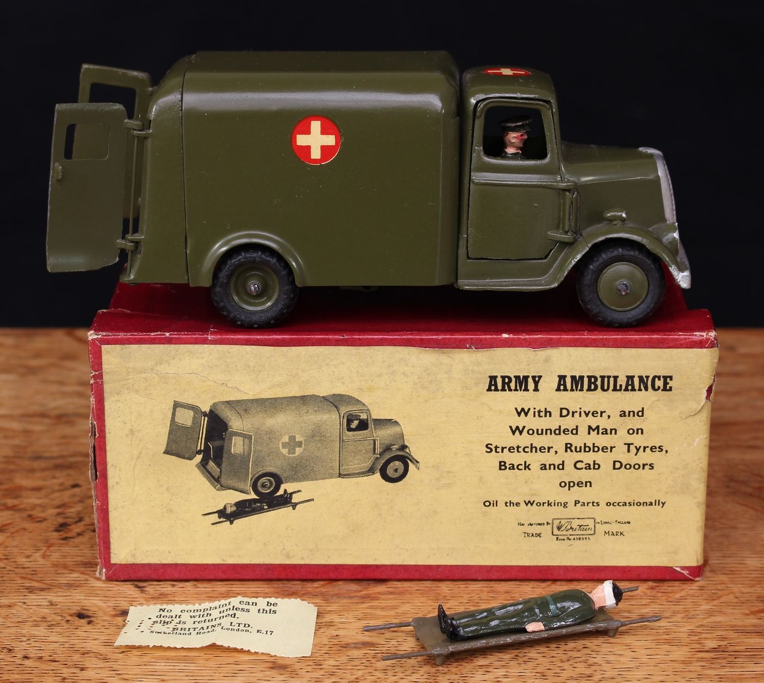 W Britain (Britains) No.1512 Army Ambulance, green body with black rubber tyres, seated driver figure, rear opening doors revealing wounded casualty figure on stretcher, boxed with original 'complaint' slip - yellow pictorial label to box lid