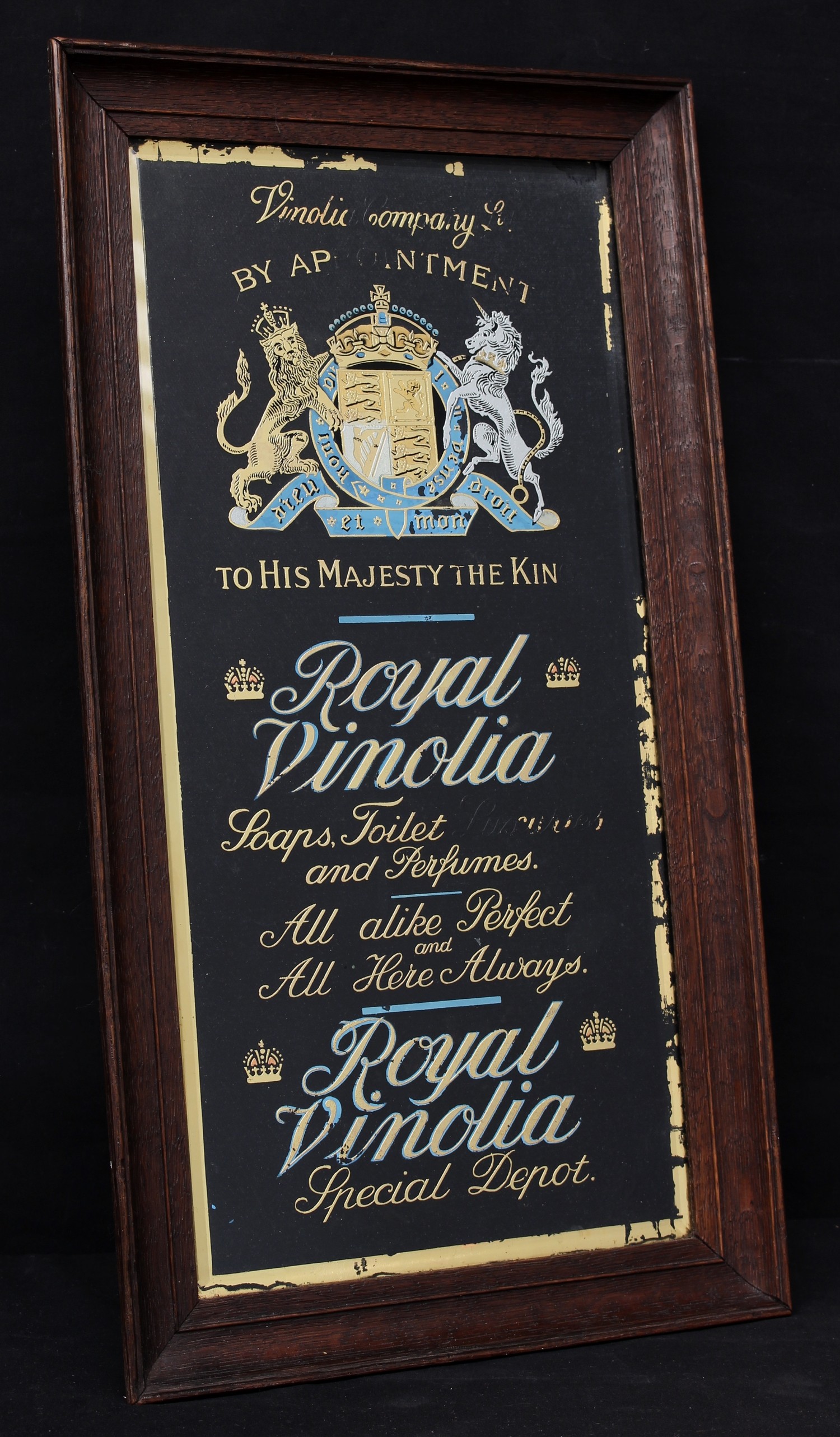 Advertising - an early 20th century Vinolia Soap rectangular reverse painted glass advertising sign, illustrated with Royal coat of arms, "Vinolia Company Ltd, BY APPOINTMENT TO HIS MAJESTY THE KING", gilt border, black velvet backing, oak framed, 51cm x 28.5cm (measurements including frame)