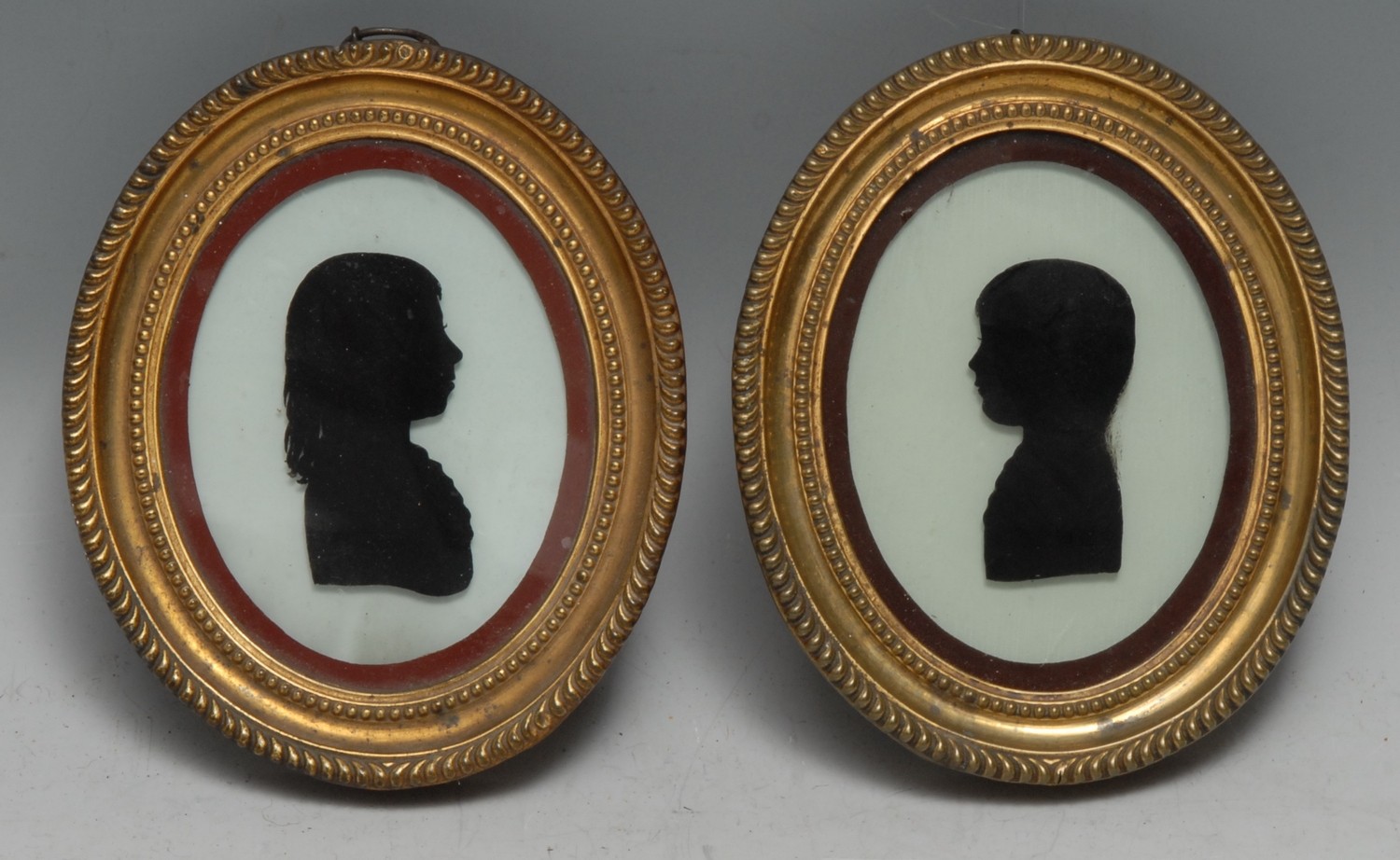 English School (18th century), a pair of portrait silhouettes, Berkley William Guise, July 1783, Aged 8 Years, and his brother (& eventual heir) John Wright Guise, July 1783, Aged 6 Years, of Highnam Court, Gloucestershire, bust-length and in profile, ovals, watercolour and glass, 9cm x 7cm