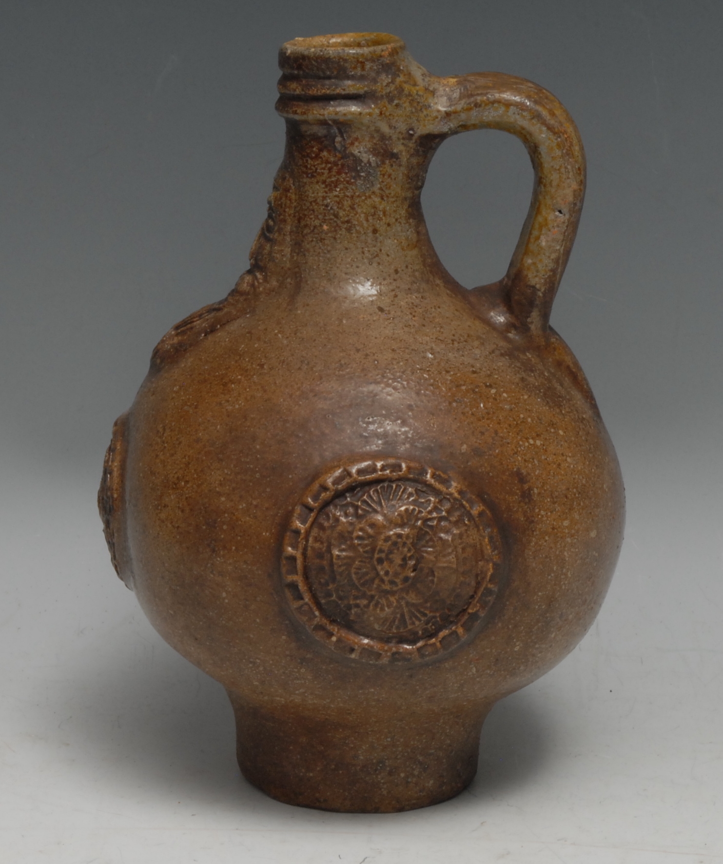 A 17th century Bellarmine brown salt-glazed stoneware jug, 21cm high, (restored and remodelled)  Provenance: Found at Hardwick Hall, Derbyshire, ink manuscript label.