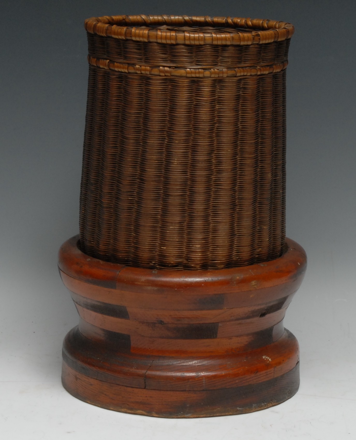 An unusual table top basket, mounted on aturned and laminated base, 31.5cm high