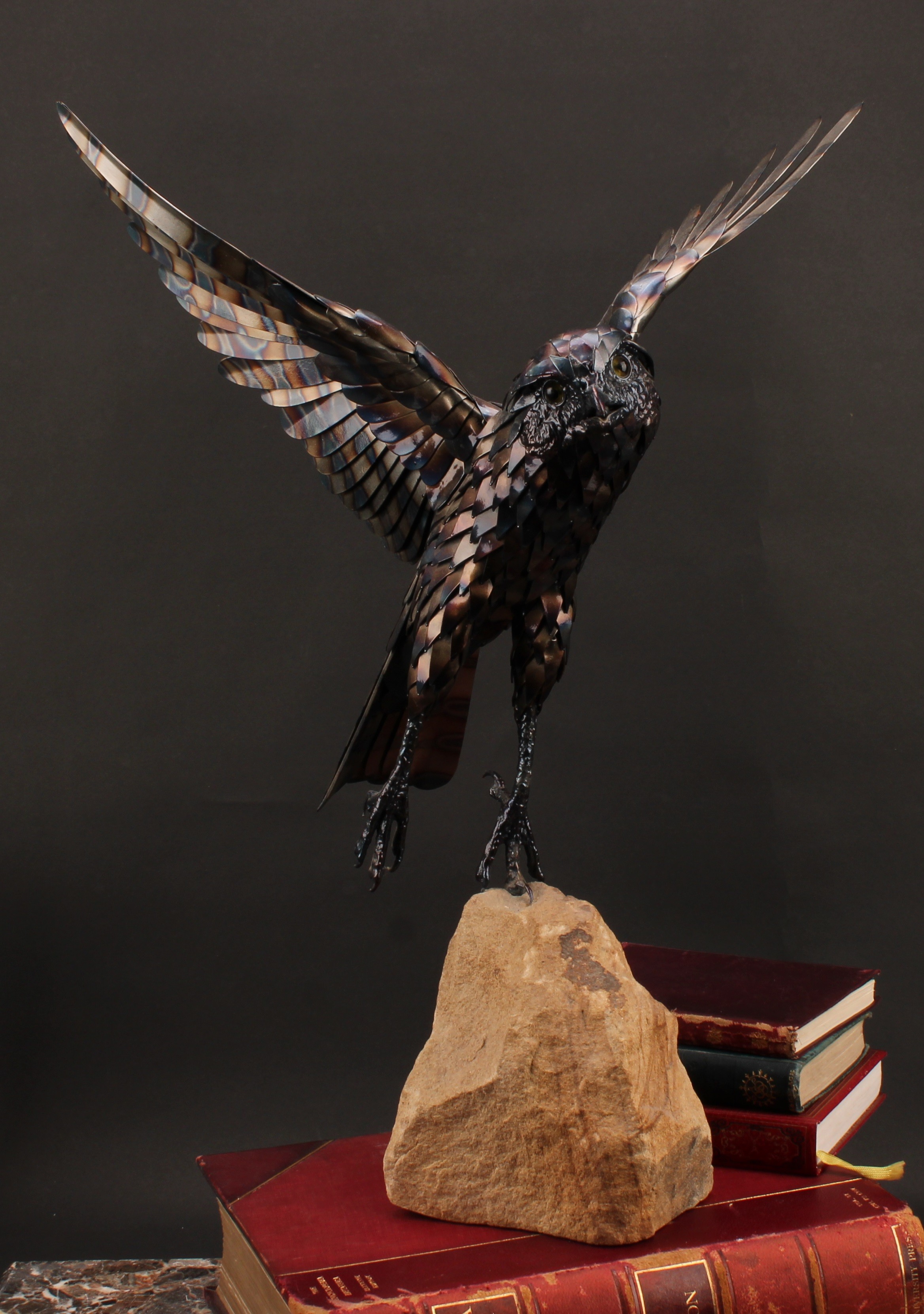 Tim Cotterill (English, bn. 1950), blued steel sculpture, of a bird of prey taking flight, mounted on rough sandstone specimen, signed, dated 1982, 55cm high