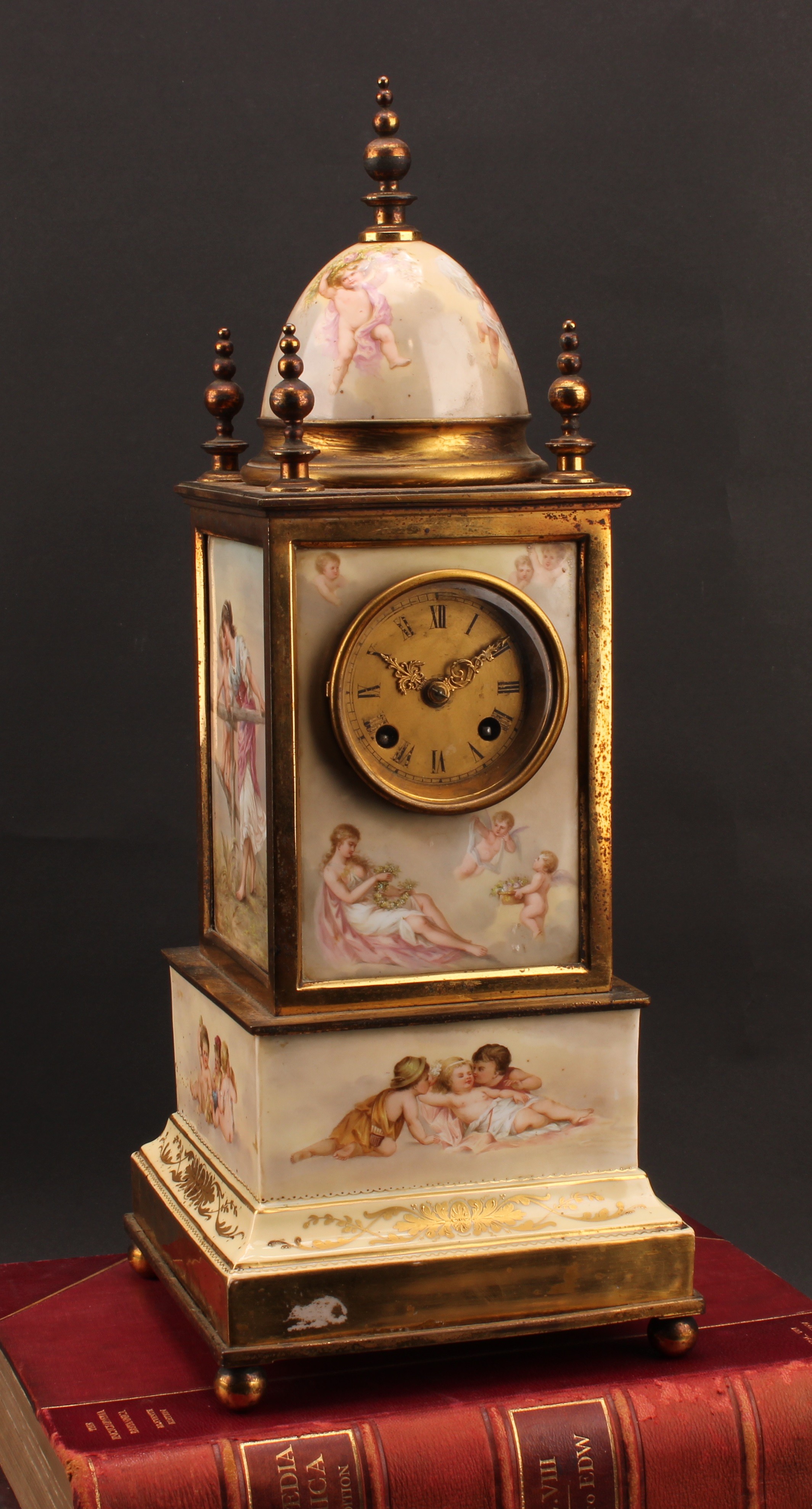 A 19th century Vienna porcelain table or mantel clock, 7cm gilt dial inscribed with Roman numerals, twin winding holes, eight-day movement striking on a bell, the architectural case crested by a dome, lacquered brass mounts, 48.5cm high, blue shield mark, c.1890