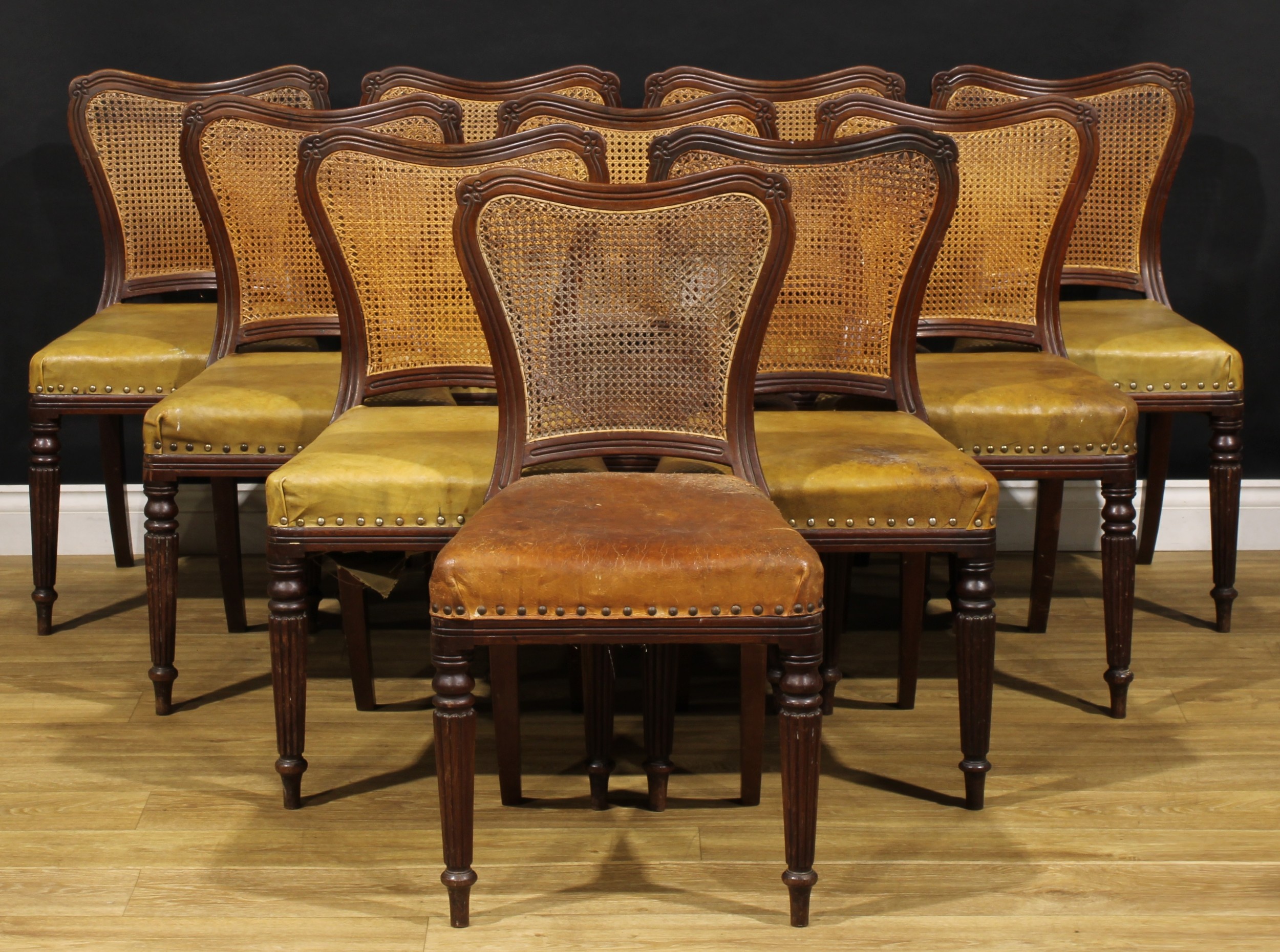 A set of ten Victorian mahogany dining chairs, in the manner of Gillows of Lancaster and London, cartouche shaped cane backs, stuffed-over seats, turned and fluted forelegs, 82cm high, 45cm wide, 47cm deep, c.1850