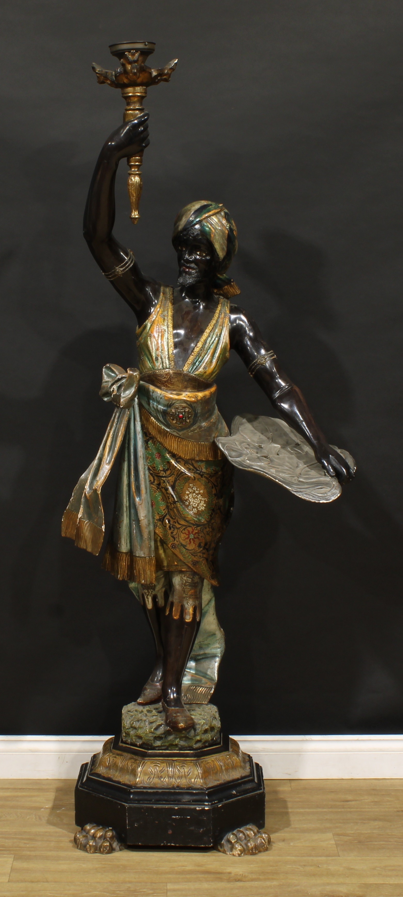 A Venetian polychrome decorated blackamoor torchère, as a Nubian figure, octagonal base, paw feet, 191.5cm high overall, late 19th/early 20th century