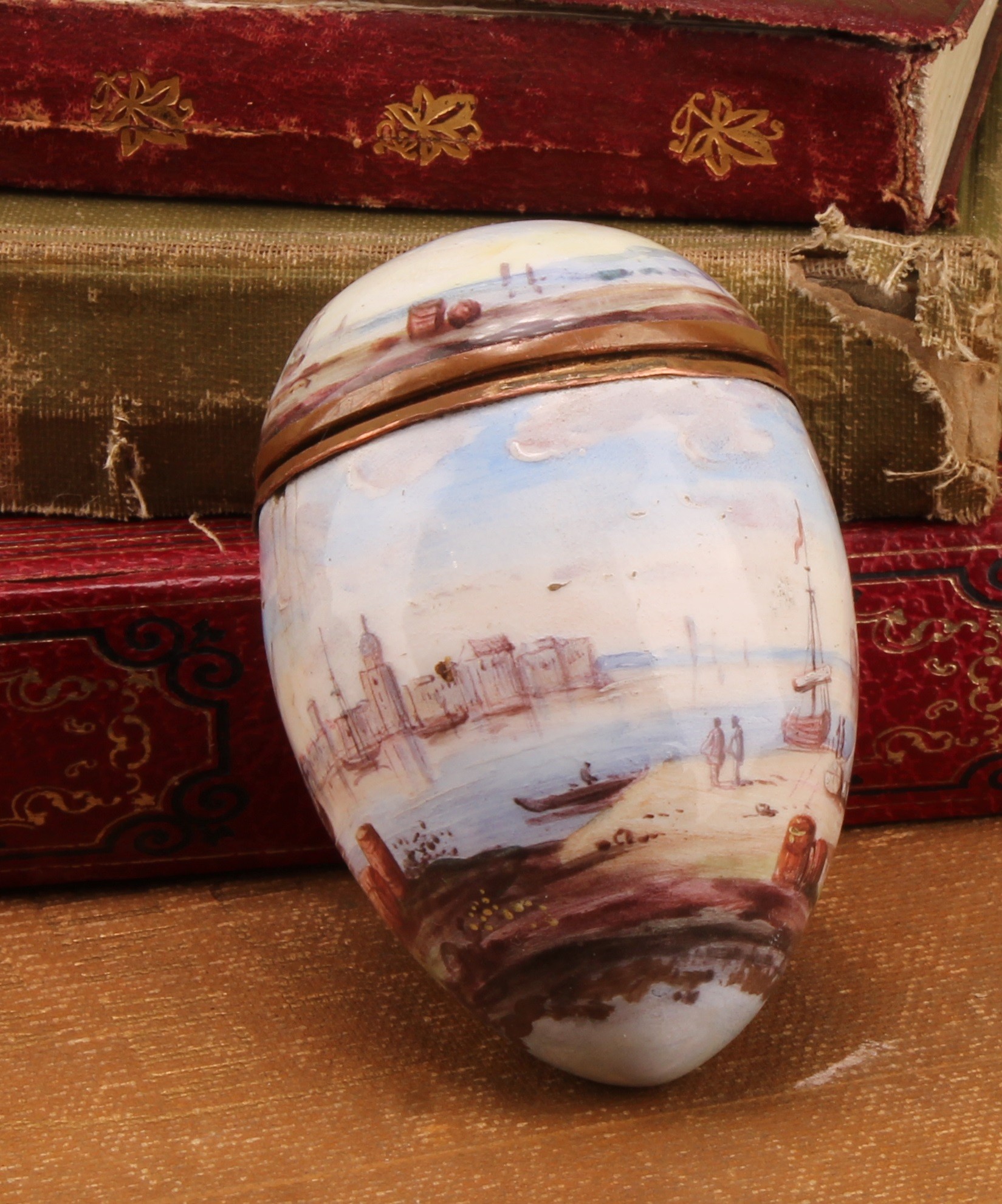 An 18th century enamel egg shaped bonbonniere, painted with a harbour scene, 7.5cm long