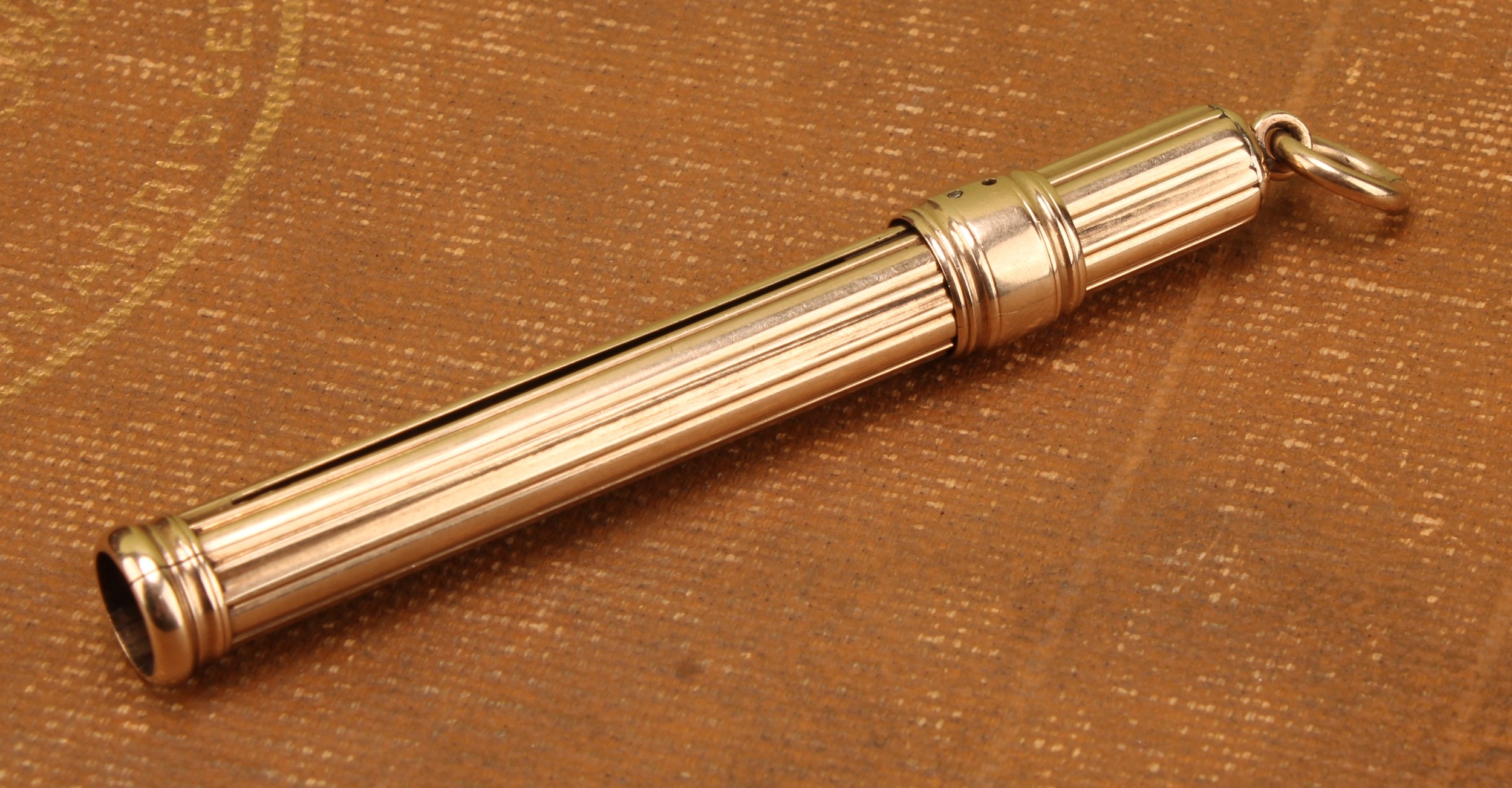A tested 9ct gold sliding pencil holder by Sampson Mordan & Co;  stamped "S.MORDAN & CO", measuring approx. 10.5cm (L), total gross weight of the pencil holder with the pencil is approx. 13.6g