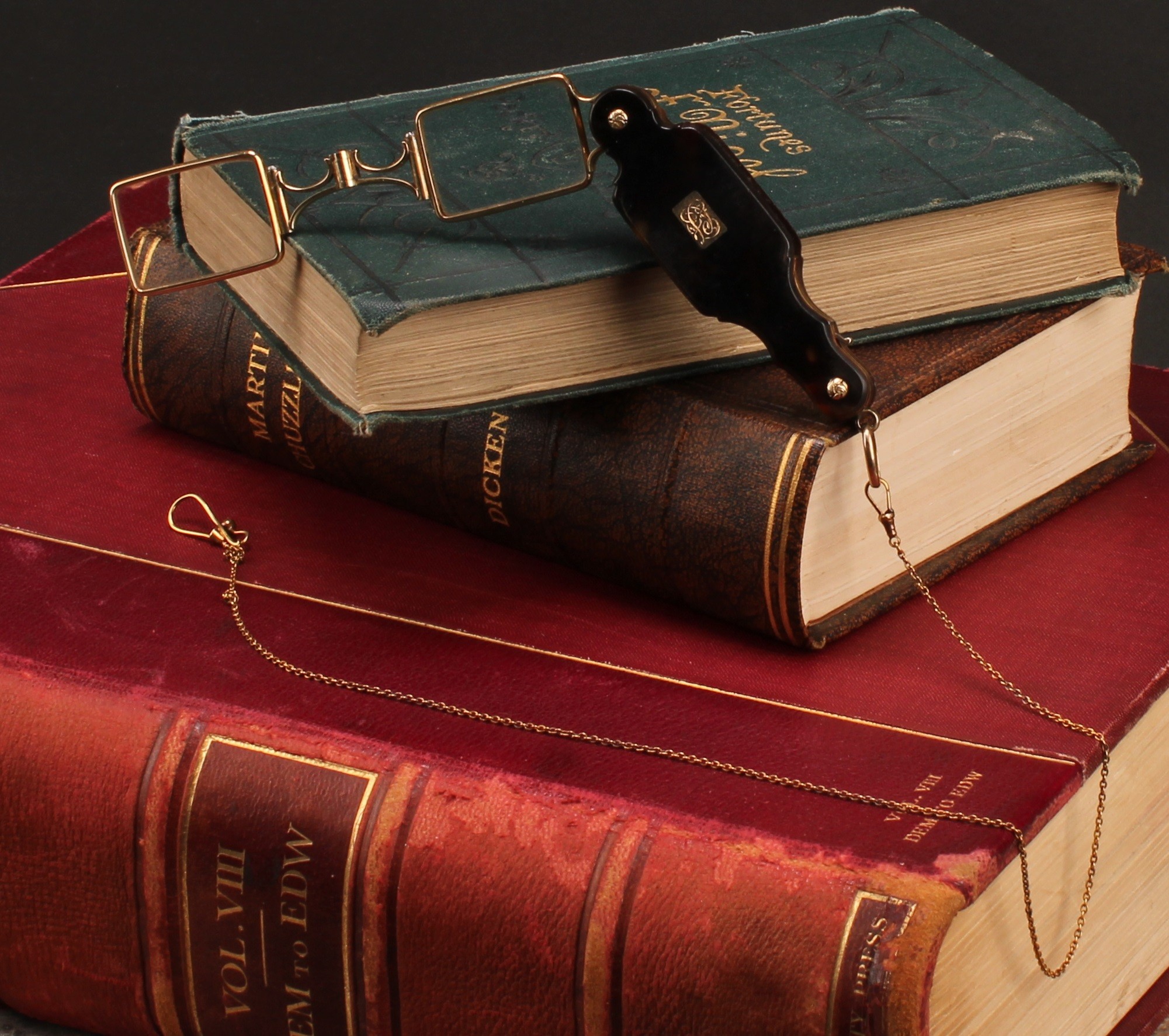 A pair of 19th century tortoiseshell and gold coloured metal lorgnettes, (testing as 14ct gold) with folding spring action, 7.5cm long closed, 15.4cm open, suspended from a fine link gold coloured metal chain, 39.5cm long