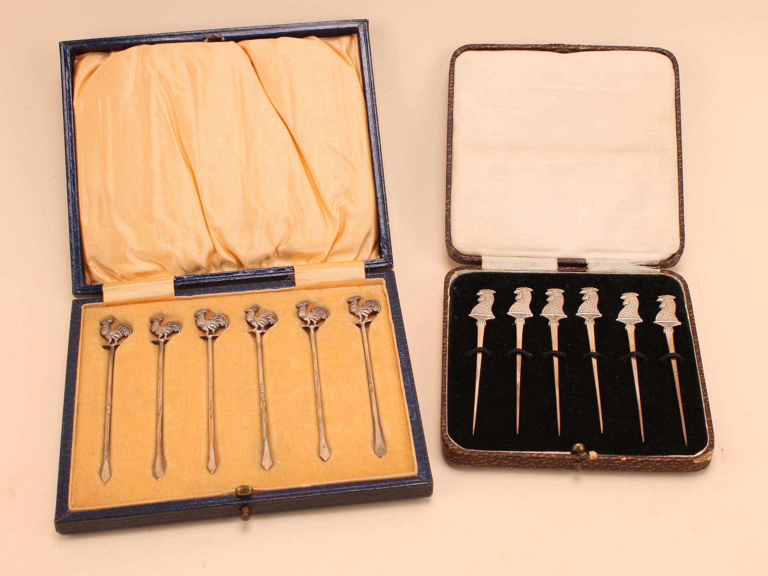 A set of six George V silver Art Deco cocktail sticks, each terminal as a cockerel, 9cm, Levi and Salaman, Birmingham 1927, cased; another set similar, James Dixon and Sons, Sheffield 1928, case (2)