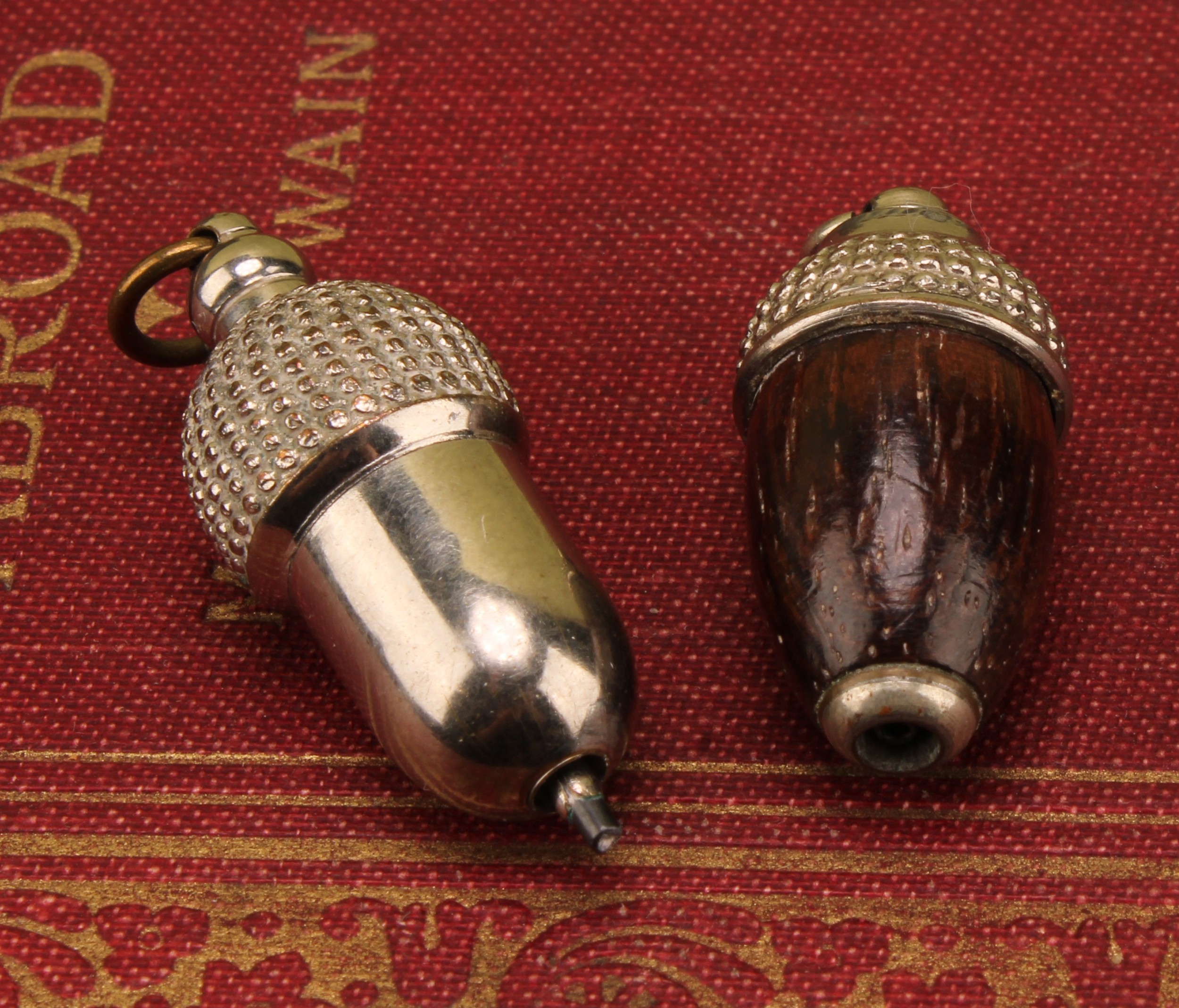 An early 20th century rosewood and base metal novelty propelling pencil, as an acorn, 3cm long; another (2)