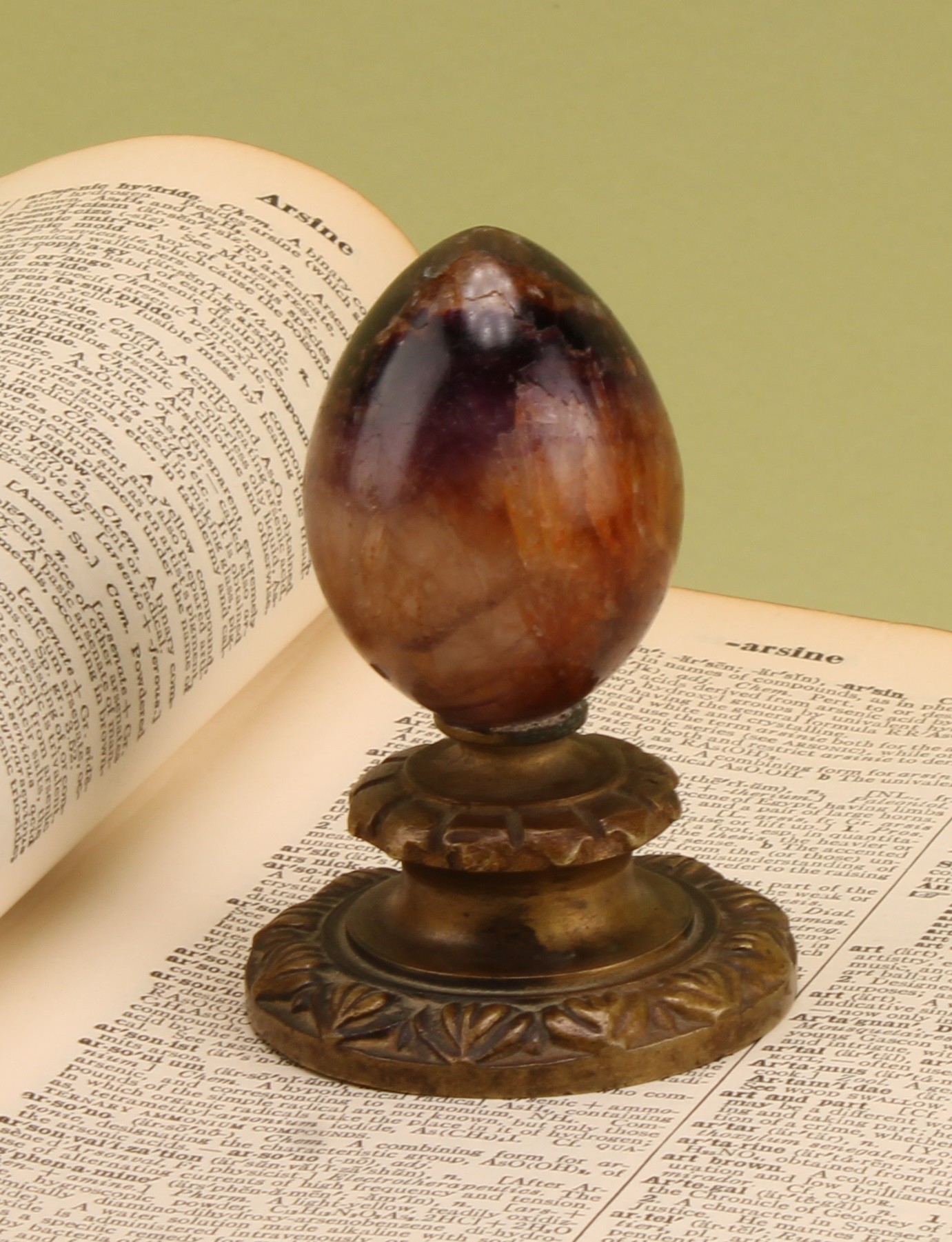 A 19th century Derbyshire Blue John and gilt bronze desk weight, polished egg shaped specimen, the circular base cast with a border of lotus, 8cm high
