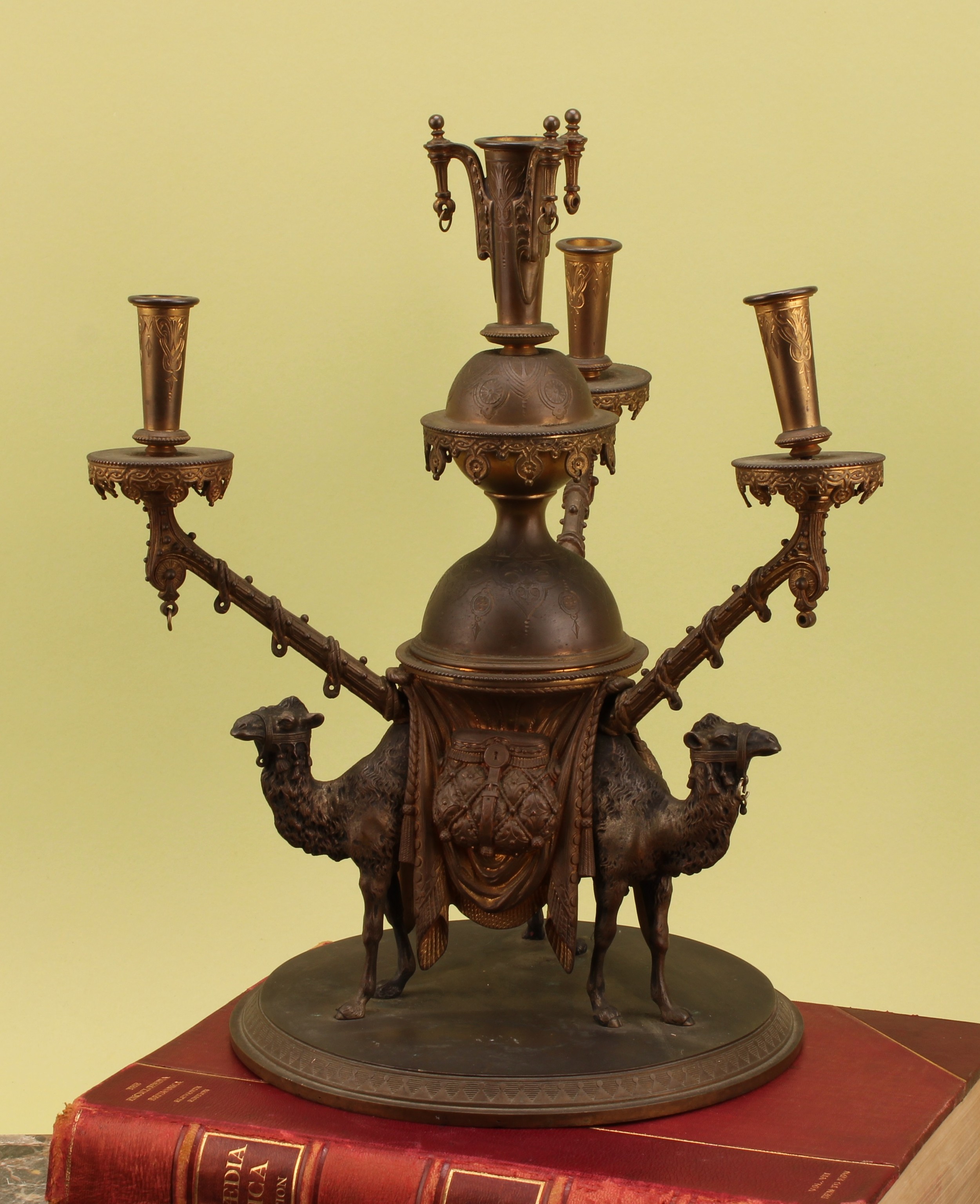 A 19th century Orientalist animalier bronze table centre, the base cast and applied with three camels, 36cm high, c.1890