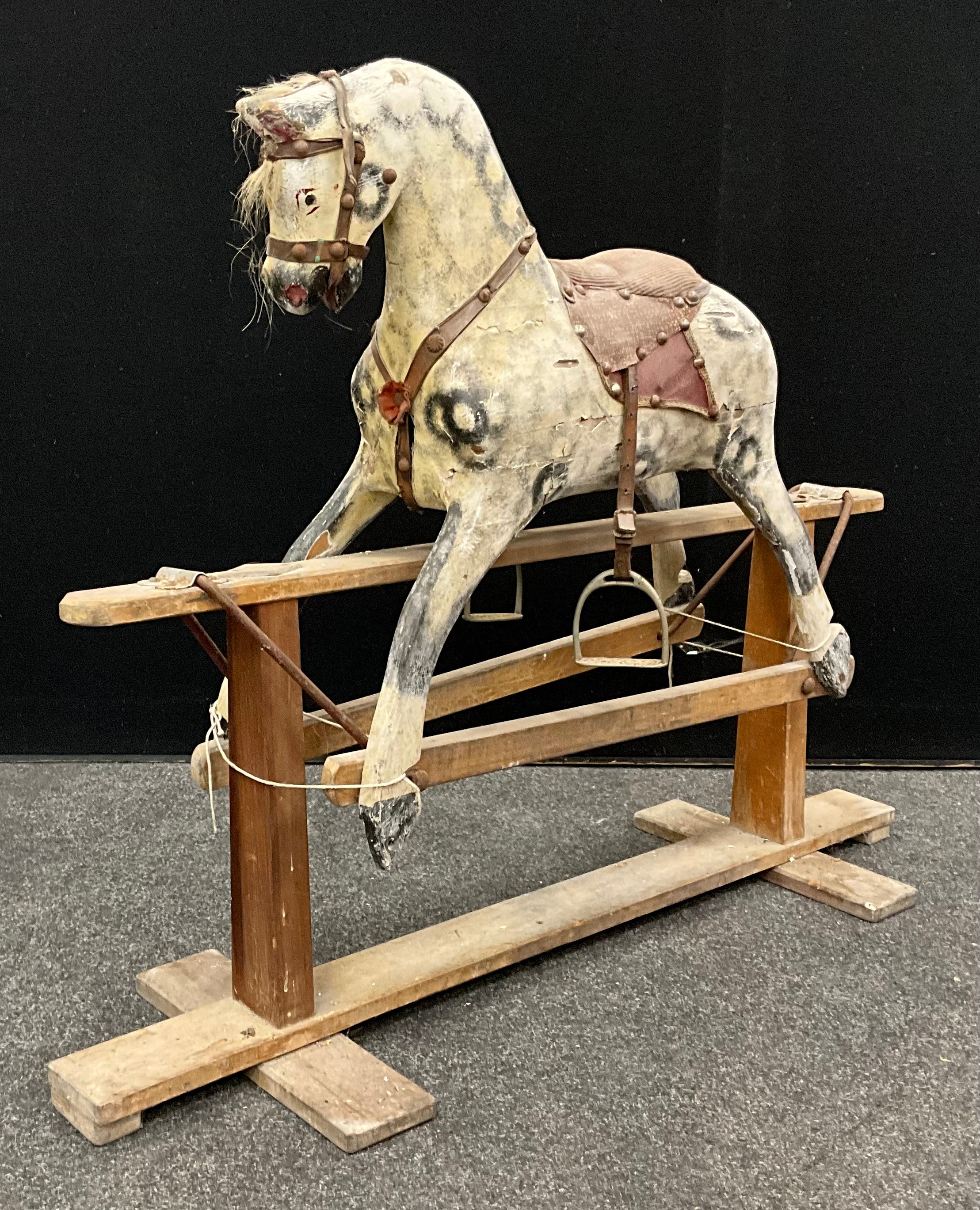 A late 19th / early 20th century rocking horse, of small proportions, carved, and painted as a Dappled Grey, 75cm high x 98cm long.