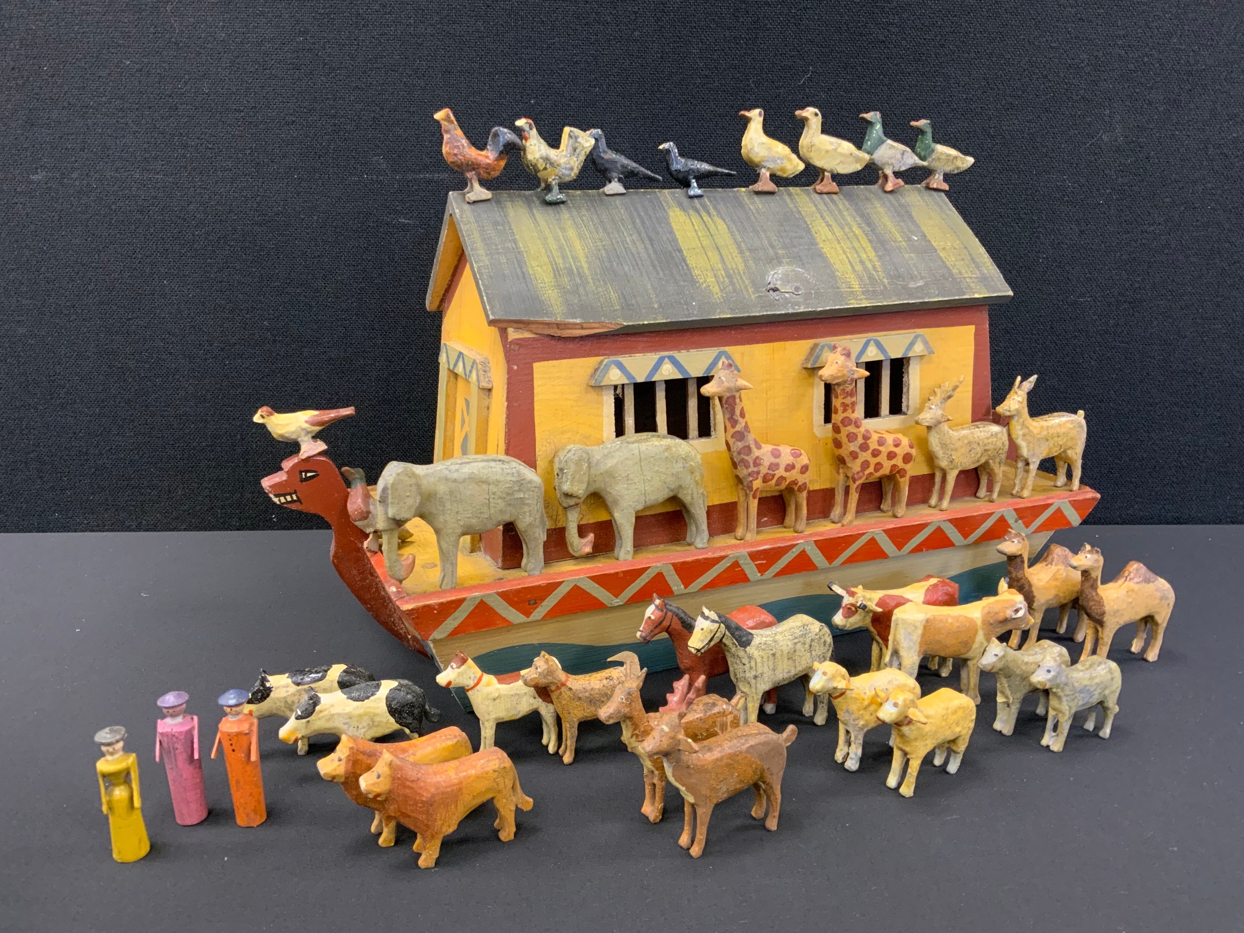 Antique Toys - A Folk art painted wooden noahs ark, pairs of animals inc giraffs, elephants, cattle, dogs, lions , Figures on the ark and many,( 1 cattle has a severed leg). There are mixed heritage from German to British and scales  and some likely Erzegebirge and others.