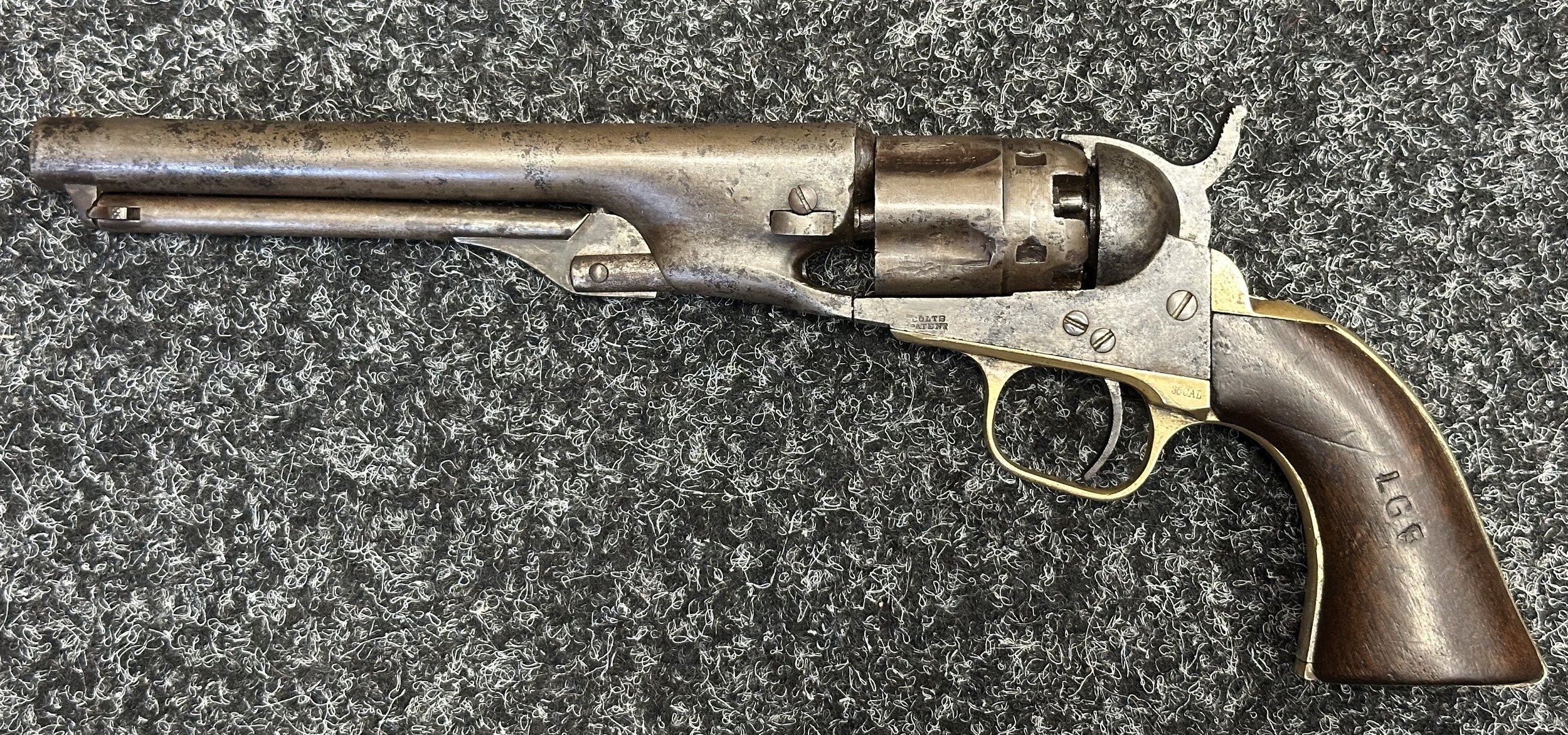 Colt .36 Cal Police Percussion Cap Revolver. All matching serial numbers 9104. Barrel length 164mm. Maker name impressed to barrel "Address Co. Saml. Colt New York US America". Working action which holds at half and full cock. Working ramrod. Cylinder impressed "Pat. Sept.10th 1853". Frame marked "Colts Patent". Brass trigger guard marked "36 Cal". Guard, frame and barrel all number 9104. Wooden grips, one impressed with owners initials "LGF". Overall length 290mm. Note: Section 58 (2) No licence required in the UK.
