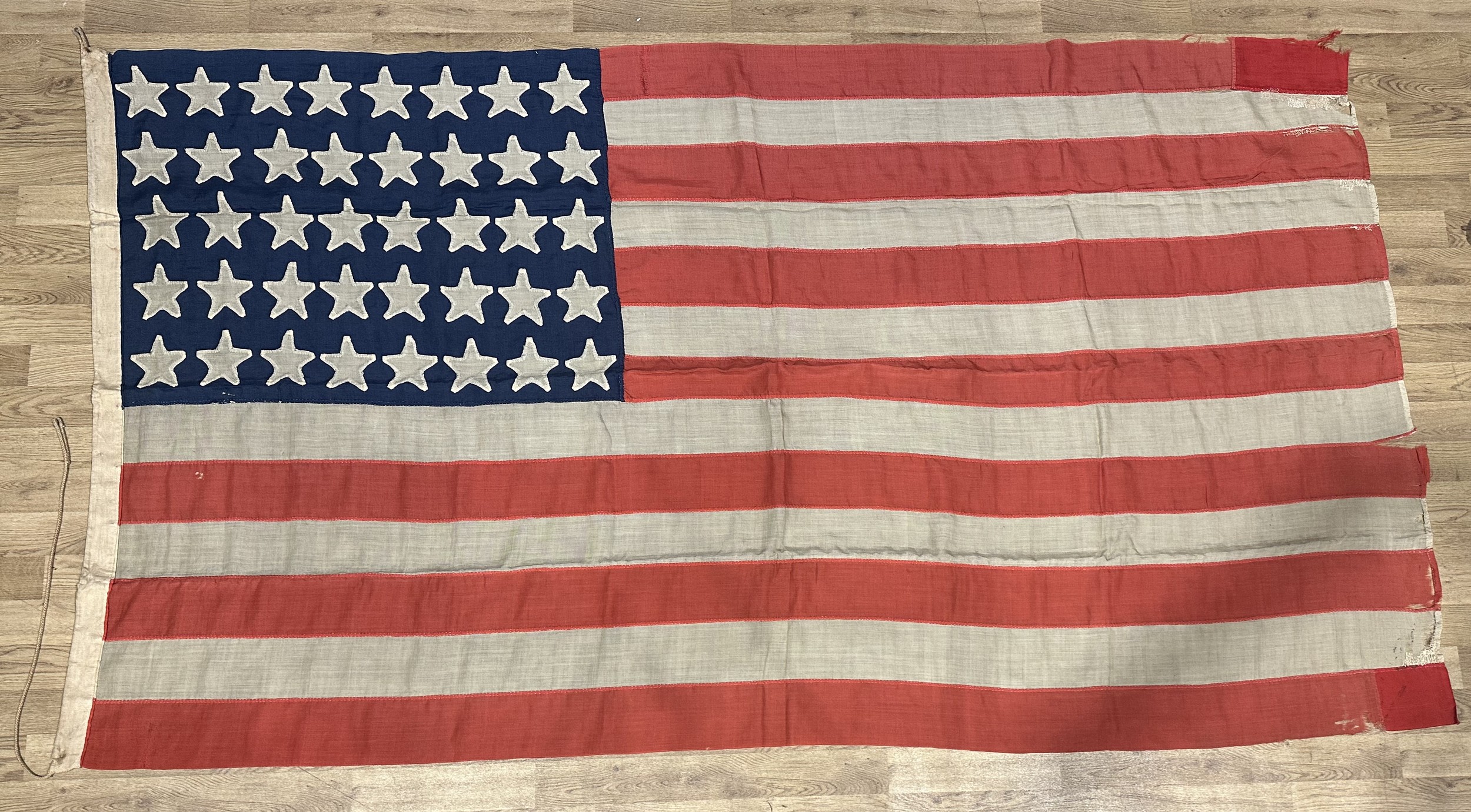 Rare 1889 US 40 Star Flag. The 40 star American flag is exceedingly rare due to the fact that most people anticipated the 39th state to be the Dakotas. Instead America received two separate states of North Dakota and South Dakota. South Dakota, the 40th state, joined the Union on November 2, 1889. The jump to 40 stars required people to rapidly adjust to the two Dakotas. Before people could produce 40 star flags in response, Montana joined the Union 6 days later as the 41st state. Montana’s introduction made 40 star flags obsolete almost immediately. Therefore, very few 40 star flags exist today, as very few were produced. Multipart construction, hand sewn example. Size 143cm x 264cm. Old repairs.