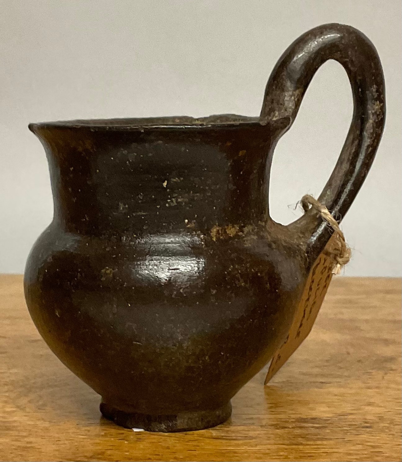 A Greek Apulian black ware single-handled kylix type wine cup, 9.5cm diam, c.4th century BC; another (2)