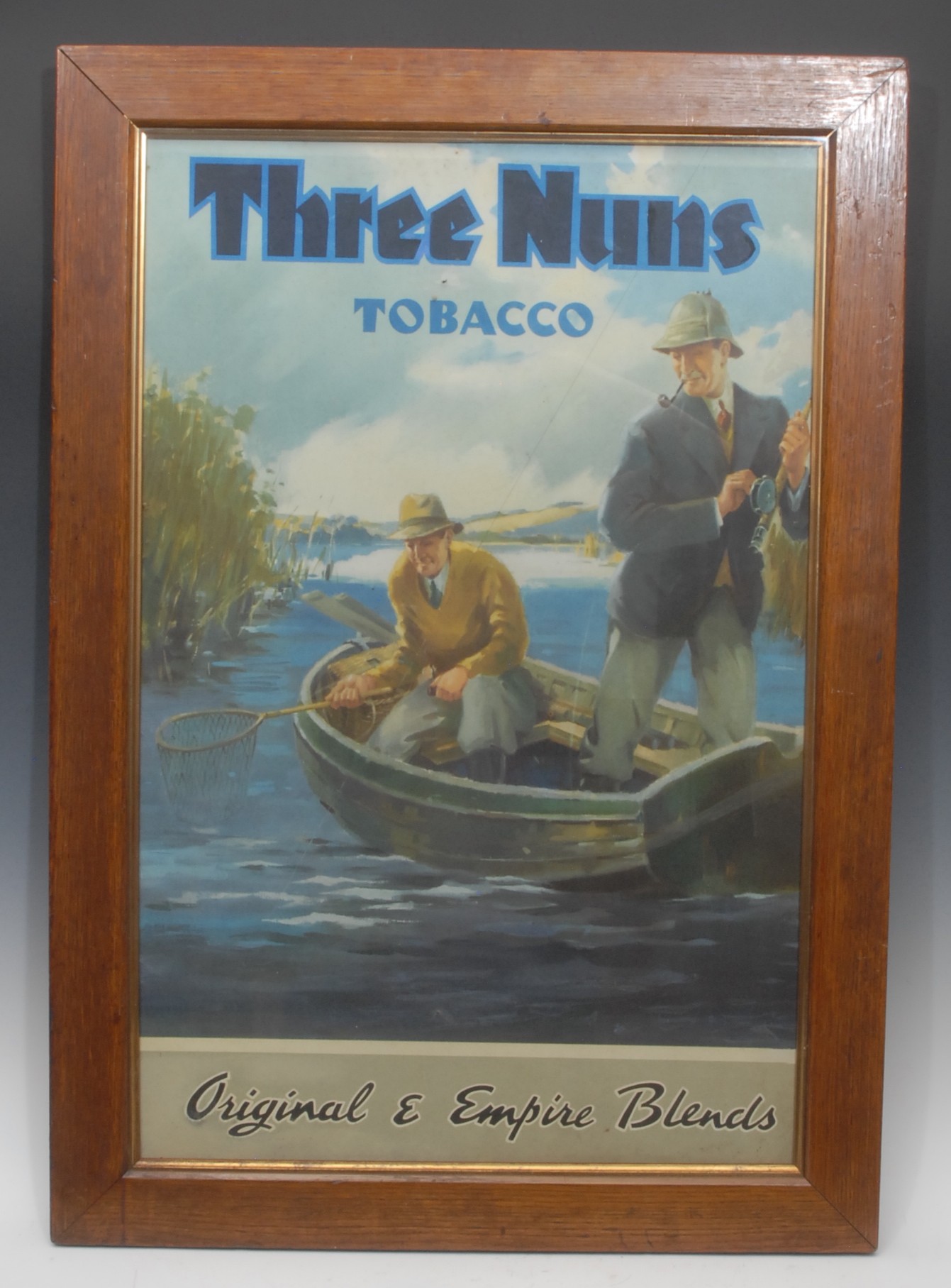 Advertising - a mid-century poster, Three Nuns Tobacco Original & Empire Blends, depicting two men fishing, 66cm x 43cm, oak frame