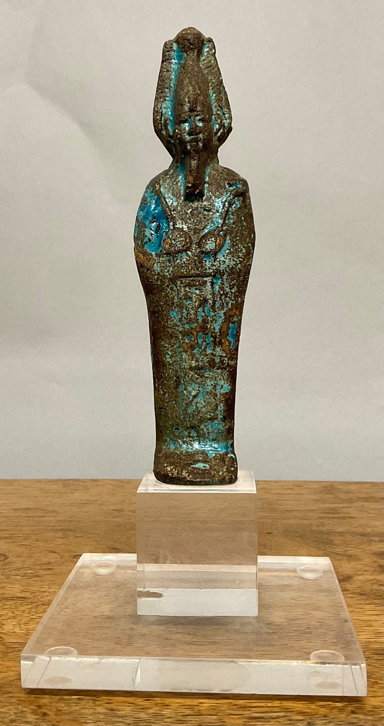 An Egyptian faience shabti, traces of turquoise glaze, 17cm high, mounted for display