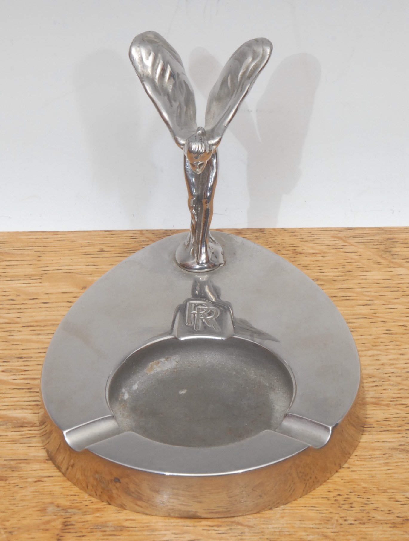 A Rolls Royce chrome plated ashtray, mounted with the Spirit of Ecstasy, after Charles Robinson Sykes (1875-1950), inscribed RR, 7.5cm high overall