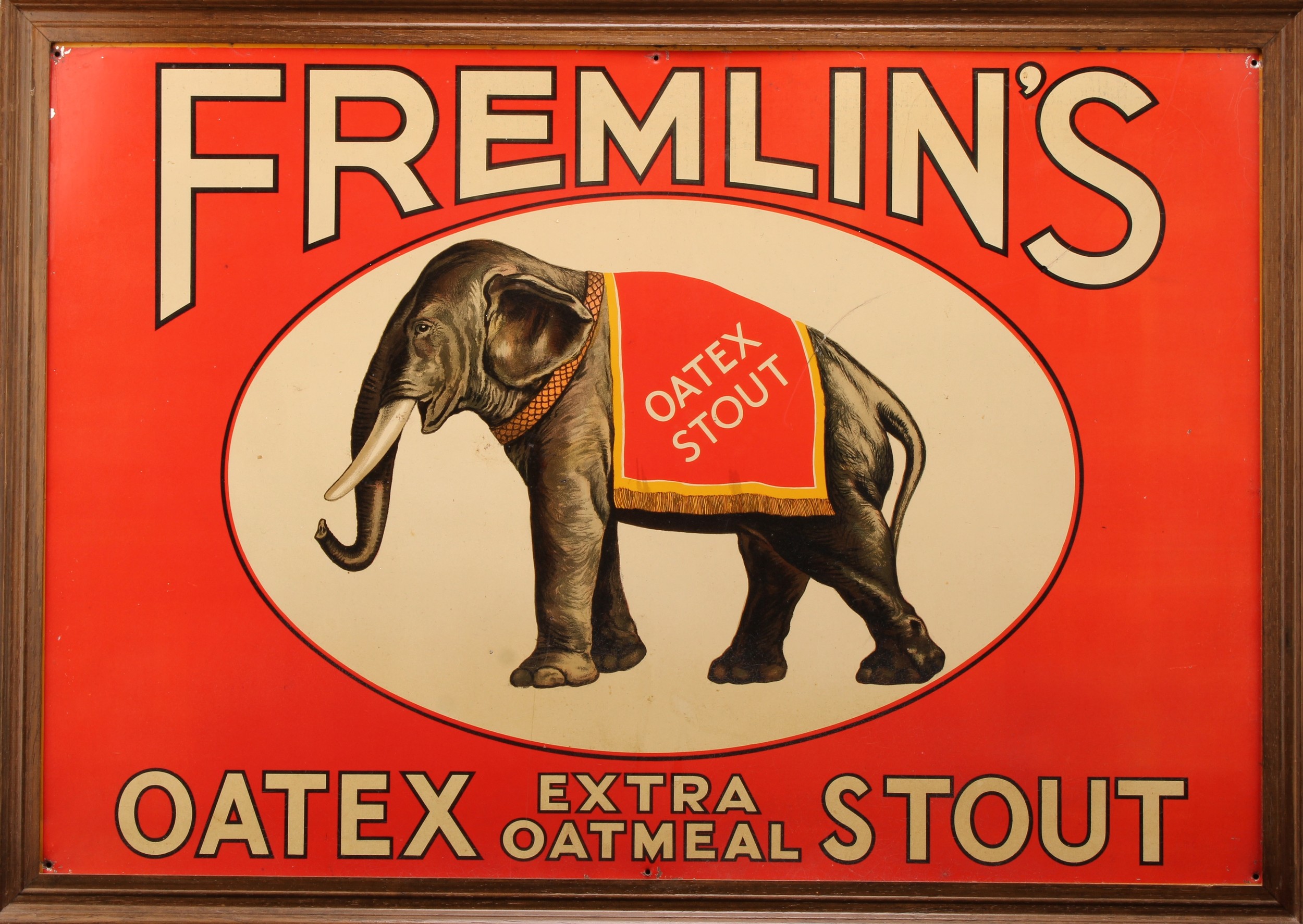 Advertising - an early to mid-20th century rectangular pictorial tin sign, Fremlin's Oatex Extra Oatmeal Stout, printed with trade mark elephant within an oval reserve, on an orange/red ground, 47cm x 69.5cm