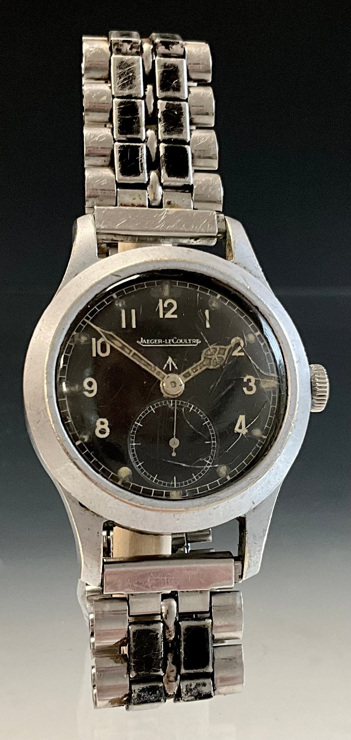 Jaeger LeCoultre - a Gentleman's World War II issue 'Dirty Dozen' alloy cased wristwatch, the black dial having cream Arabic numerals, seconds subsidiary dial at 6 o'clock, luminous filled second and hour hands, screw action case back, marked with broad arrow, 'WWW' and numbered '282985' and 'F12323', signed manual wind movement numbered '324886', 35mm diameter (ex. crown), later metal strap
